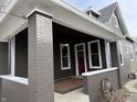 Brick porch with a red front door and ceiling fan at 1525 S New Jersey St, Indianapolis, IN 46225