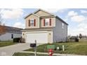 Two-story house with a beige exterior, red shutters, and a driveway at 5772 Weeping Willow Pl, Whitestown, IN 46075