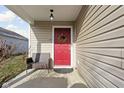 Red front door with a wreath, a porch, and a wicker chair at 5772 Weeping Willow Pl, Whitestown, IN 46075