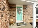 Charming teal front door with wreath and welcome mat at 600 Brentwood W Dr, Plainfield, IN 46168