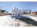 White house exterior with a snowy yard and wooden fence at 7748 Hotze St, Indianapolis, IN 46259