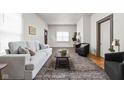 Light and airy living room with gray sofa and dark accent chairs at 85 E Poplar St, Zionsville, IN 46077