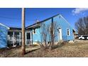 Side view of a blue house with a screened porch and yard at 901 W Marsh St, Muncie, IN 47303