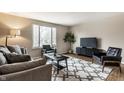 Modern living room featuring a large window, stylish furniture, and a contemporary rug at 9229 Thrushwood Ln, Indianapolis, IN 46250