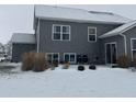 Gray house with back patio, snowy yard, and landscaping at 9426 Orchard Cove Dr, Indianapolis, IN 46239
