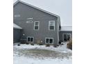 Gray house with snowy yard, and multiple windows at 9426 Orchard Cove Dr, Indianapolis, IN 46239