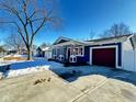 Blue house on a tree lined street with snow on the ground at 9519 Meadowlark Dr, Indianapolis, IN 46235
