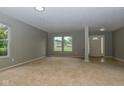 Bright living room with neutral paint, carpet, and plenty of natural light from large windows at 10391 Butler Dr, Brownsburg, IN 46112