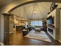 Open-concept living room with vaulted ceilings, fireplace, and wood floors, perfect for entertaining at 11253 Loch Raven Blvd, Fishers, IN 46037