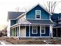 Two-story blue house with white trim, front porch, and a lime green door at 2502 N Harding N St, Indianapolis, IN 46208