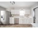 Bright kitchen featuring white cabinets, stainless steel appliances, and wood grain vinyl floors at 3017 Sherman St, Anderson, IN 46016