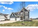 Two-story house with gray siding, white garage doors, and a tree in the front yard at 3572 Blenheim Pl, Westfield, IN 46074