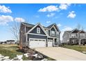 Two-story home with gray siding, white garage doors, and landscaping at 3572 Blenheim Pl, Westfield, IN 46074