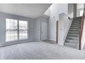 Bright living room featuring large window, neutral carpet, fresh paint, and stairway to the upper level at 368 Seabreeze Cir, Avon, IN 46123