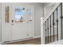 Front entry with white door, wood floors, and black metal railing at 4155 Senour Rd, Indianapolis, IN 46239
