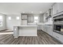Modern kitchen featuring an island, stainless steel appliances, and sleek light gray cabinetry at 7300 Legends Way, Whitestown, IN 46052