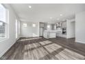 Open-concept living area with hard surface floors seamlessly transitioning to the stylish kitchen at 7300 Legends Way, Whitestown, IN 46052