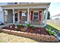 Brick-bordered flower bed and two benches on the covered porch at 833 Palisades Ct, Greenwood, IN 46143