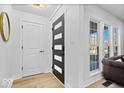 Bright entryway with a modern dark gray door and light wood floors at 923 E Pleasant Run Pkwy S Dr, Indianapolis, IN 46203
