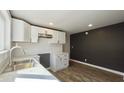 Renovated kitchen featuring white cabinets, marble countertops, and dark-gray walls at 929 N Bancroft St, Indianapolis, IN 46201