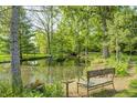 Tranquil pond with a bench, offering a peaceful retreat surrounded by lush trees and greenery at 9600 N 500 E, Pendleton, IN 46064