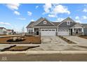 Beautiful townhome with a two-car garage, gray siding, stone accents, and professionally landscaped front yard at 16964 Cattle Hollow Ln, Noblesville, IN 46060