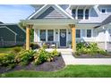 Charming front porch with wooden posts, seating, and flowerbeds at 19950 Chatham Green Dr, Westfield, IN 46074