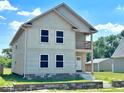 Two-story house with beige siding, balcony, and stone accents at 2913 Macpherson Ave, Indianapolis, IN 46205