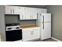 White kitchen with wood countertops and black appliances at 302 E Cowing Dr, Muncie, IN 47303