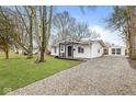 White ranch house with gravel driveway and detached garage at 4048 Breton St, Indianapolis, IN 46222