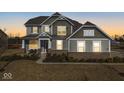 Two-story house with gray siding, brick accents, and a landscaped lawn at 4416 Voyageur Way, Carmel, IN 46074