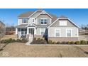 Two-story house with gray siding, brick accents, and a landscaped lawn at 4416 Voyageur Way, Carmel, IN 46074