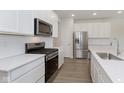 Modern kitchen featuring stainless steel appliances, white cabinets, and quartz countertops at 7254 Shroyer Way, Noblesville, IN 46062