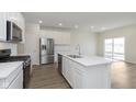 Modern kitchen featuring stainless steel appliances, a center island, and sleek white cabinets at 7254 Shroyer Way, Noblesville, IN 46062