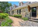 Stone pathway leading to a charming home exterior, featuring manicured landscaping with flowers and greenery at 7837 Dean Rd, Indianapolis, IN 46240