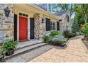 Close up of the front entrance featuring a red door, stone facade, and professional landscaping at 7837 Dean Rd, Indianapolis, IN 46240