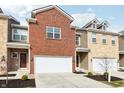Inviting townhome showcasing a brick facade, one-car garage, and well-maintained landscaping at 11436 Mossy Ct # 102, Fishers, IN 46037