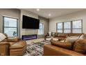 Comfortable living room featuring a modern fireplace, a large TV, and a plush leather sectional sofa at 1224 Keystone Ave, Indianapolis, IN 46201
