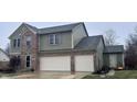Two-story house featuring green and brick exterior, two-car garage, and landscaping at 1271 N Manchester Dr, Greenfield, IN 46140