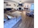 Spacious living room with a sectional sofa, fireplace, and wood-look floors at 1271 N Manchester Dr, Greenfield, IN 46140