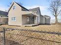 Tan house with a covered porch and fenced yard at 320 W 6Th St, Muncie, IN 47302