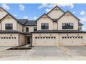 Townhouse showcasing a two-car garage, modern design elements, and tidy landscaping under a blue sky at 4183 Douro Trl, Westfield, IN 46062