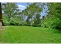 Large backyard featuring expansive lawn area and mature trees, providing ample space and a park-like feel at 4820 E 70Th St, Indianapolis, IN 46220