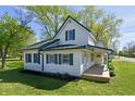 Two-story home featuring a green roof, white siding, and a cozy side porch at 4992 W 100 S, New Palestine, IN 46163