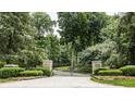 Ornate iron gate opens to a tree-lined driveway at 5101 Green Braes E Dr, Indianapolis, IN 46234
