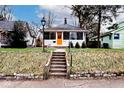 View of home with a charming front yard and vibrant landscaping with an inviting orange door at 5630 Winthrop Ave, Indianapolis, IN 46220