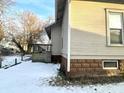 Side view of tan house with small deck and snowy yard at 808 S Burlington Dr, Muncie, IN 47302