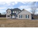 A two-story home is featured with gray siding, blue shutters, and a well-kept lawn at 9222 W State Road 38, Lapel, IN 46051