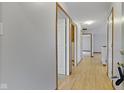 Light-toned hallway with hardwood floors and doors to bedrooms and other rooms at 101 Country Ct, Danville, IN 46122