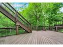 A spacious wood deck with stairs leading to a yard with lush greenery and a multi-level wooden patio at 14565 Geist Ridge Dr, Fishers, IN 46040